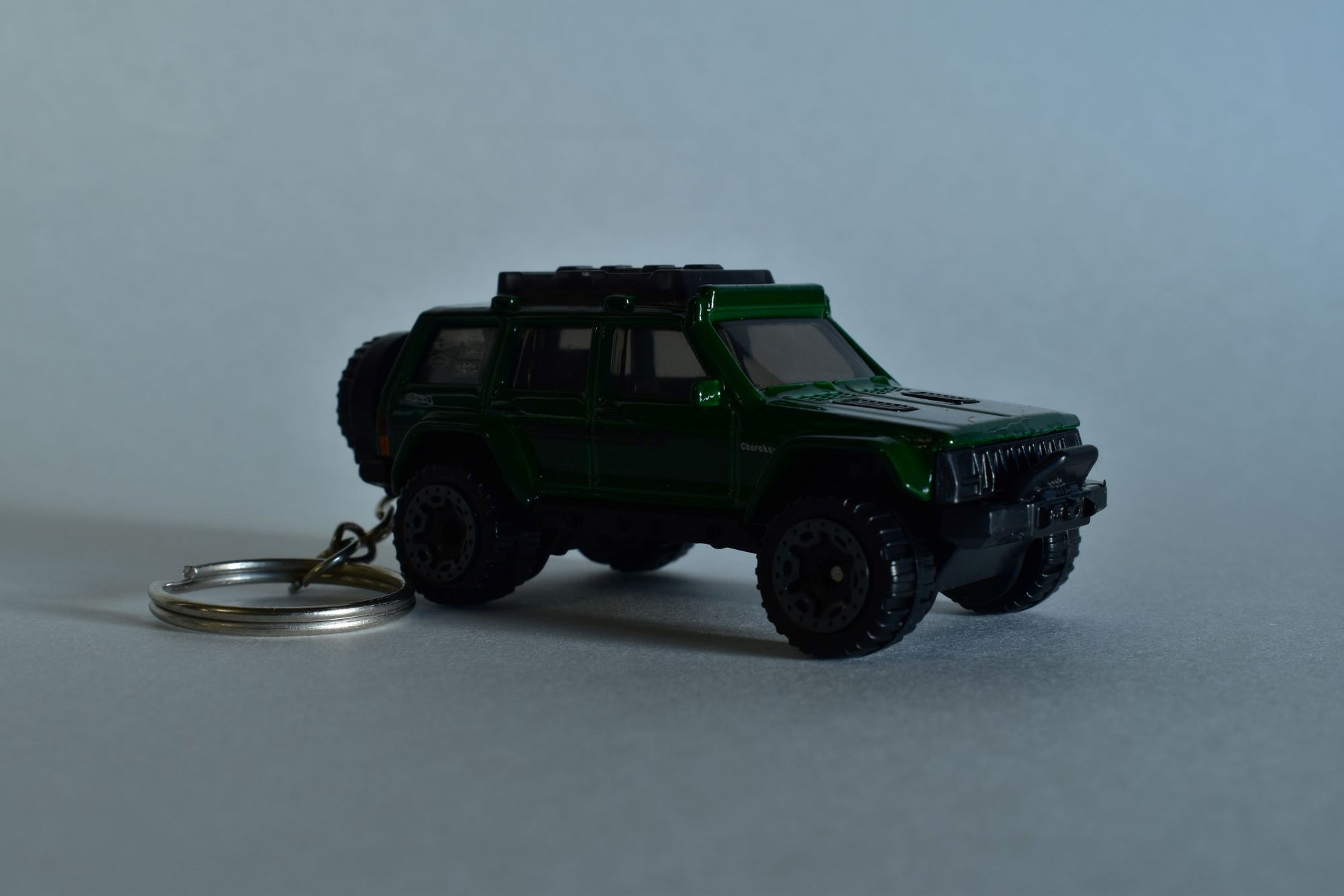 Green Hotwheels Jeep Cherokee keychain on a white background