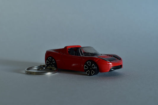 Red Hotwheels Tesla Roadster keychain on a white background