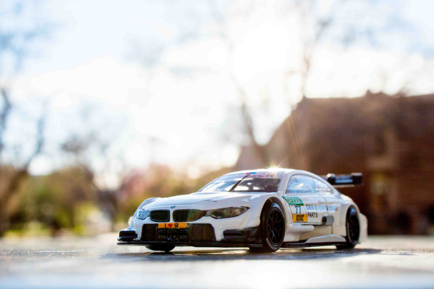 White BMW M4 DTM shining in the sunlight over a blurred natural background.