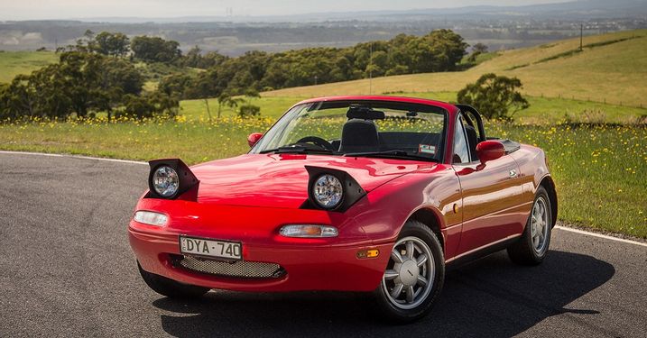 Red Mazda Miata with popup headlights